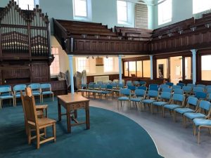 Lightweight wooden stacking chairs for Taunton united reformed church, and in the background lightweight high stacking sled base or skid base upholstered chairs